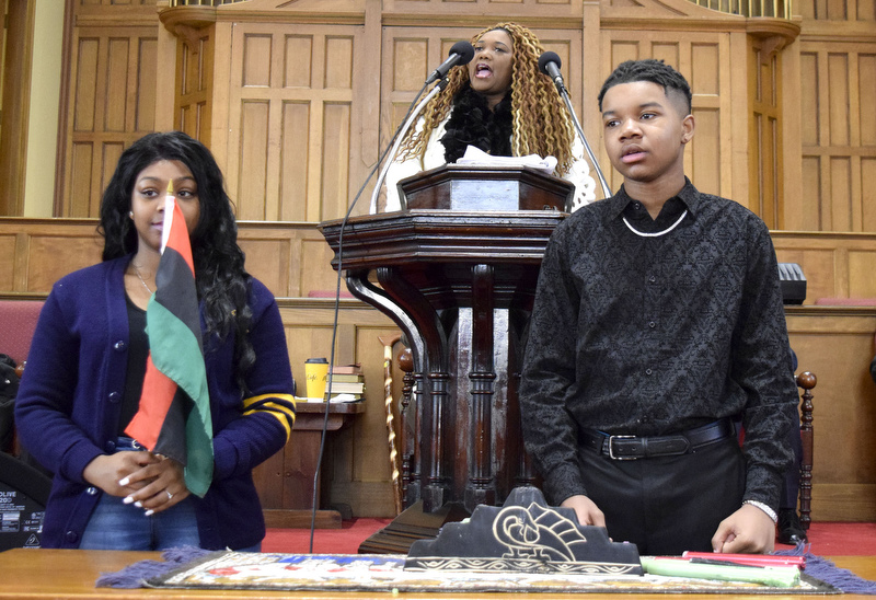 Staff Photo by Robin Rudd/   With the help of two young people Reverend Charlotte S. N.N. Williams, of the Eastdale Village Community UMC speaks on the principles of Kwanza.  T