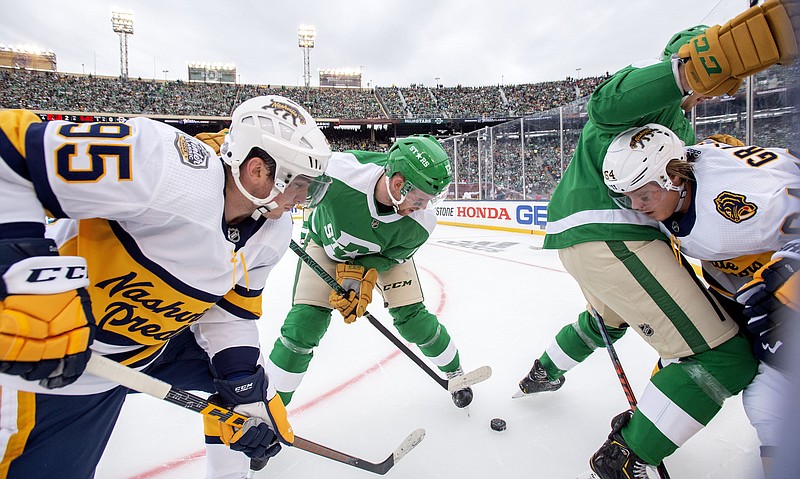 Nashville Predators teammates Matt Duchene (95) and Mikael Granlund battle for the puck with Dallas Stars teammates Radek Faksa, left, and Jamie Oleksiak in the first period of the NHL Winter Classic on Wednesday at Cotton Bowl Stadium in Dallas. / AP photo by Jeffrey McWhorter