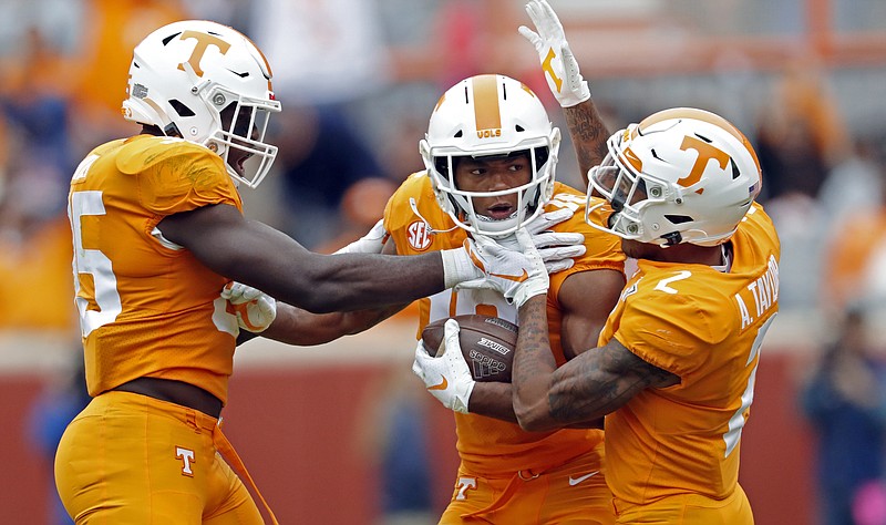 Tennessee senior Nigel Warrior, center, celebrates with fellow defensive back Alontae Taylor, right, and linebacker Daniel Bituli after intercepting a pass during the second half of a home game against Mississippi State on Oct. 12. / AP photo by Wade Payne