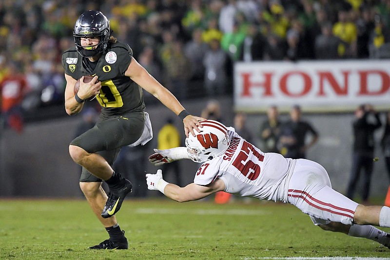 Oregon quarterback Justin Herbert runs for a touchdown past Wisconsin linebacker Jack Sanborn during the second half of the Rose Bowl Game on Wednesday in Pasadena, Calif. / AP photo by Mark J. Terrill