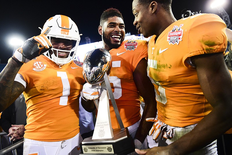 Tennessee's Jauan Jennings, center, holds the TaxSlayer Gator Bowl trophy next to fellow wide receivers Marquez Callaway (1) and Josh Palmer after the Vols beat Indiana 23-22 on Thursday night in Jacksonville, Fla. / AP photo by Calvin Mattheis