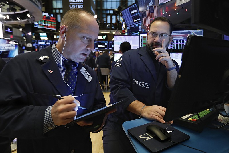 FILE - In this Dec. 11, 2019, file photo trader Michael Urkonis, left, and specialist Anthony Matesic work on the floor of the New York Stock Exchange. The U.S. stock market opens at 9:30 a.m. EST on Friday, Jan. 3, 2020. (AP Photo/Richard Drew, File)