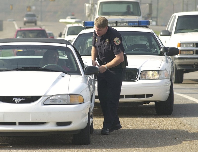 Traffic safety officer Brian Hickman of the Collegdale police department talks with a motorist he stopped for speeding Wednesday afternoon. He issued a warning ticket to the driver. / Staff Photo by John Rawlston 
