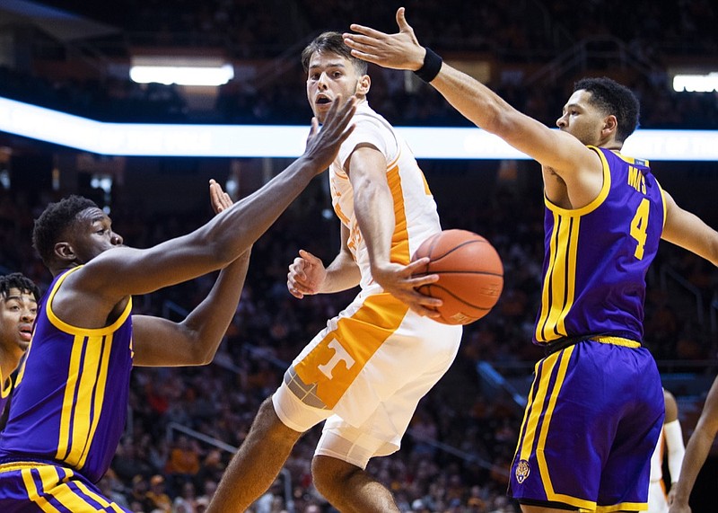 Tennessee guard Santiago Vescovi passes in between two LSU defenders during Saturday's SEC opener for both teams at Thompson-Boling Arena in Knoxville. Vescovi scored 18 points, all on 3-point shots, in his college debut, but the Vols lost 78-64. / AP photo by Brianna Paciorka