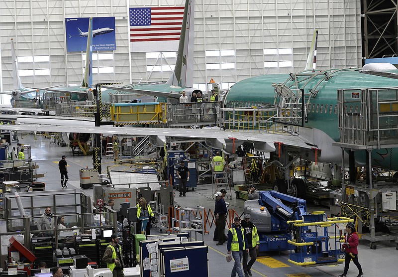 In this March 27, 2019, file photo people work on the Boeing 737 MAX 8 assembly line during a brief media tour in Boeing's 737 assembly facility in Renton, Wash. On Friday, Jan 3, 2020, the Institute for Supply Management, an association of purchasing managers, reports on activity by U.S. manufacturers in December. (AP Photo/Ted S. Warren, File)