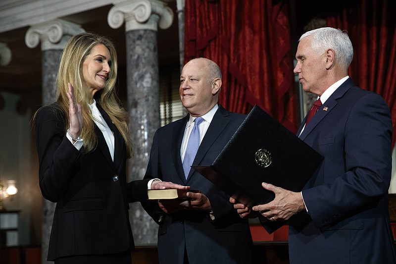 Sen. Kelly Loeffler, R-Ga., left, with her husband Jeffrey Sprecher, center, participates in a re-enactment of her swearing-in Monday Jan. 6, 2020, by Vice President Mike Pence in the Old Senate Chamber on Capitol Hill in Washington. (AP Photo/Jacquelyn Martin)