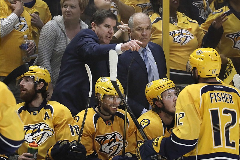 In this May 7, 2017, file photo, Nashville Predators coach Peter Laviolette, center left, and associated coach Kevin McCarthy, center right, talk during Game 6 of a second-round NHL hockey playoff series against the St. Louis Blues in Nashville, Tenn. The team announced Monday, Jan. 6, 2020, that both Laviolette and McCarthy have been fired. (AP Photo/Mark Humphrey, File)