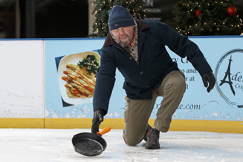 Slippery When Frozen team member Michael Hall throws a skillet during the 2019 Iron Skillet Curling Tournament held at Ice on the Landing in the Chattanooga Choo Choo Gardens. / Staff File Photo by C.B. Schmelter