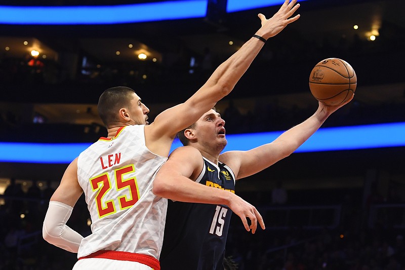 Denver Nuggets center Nikola Jokic, right, shoots as Atlanta Hawks center Alex Len (25) defends during the second half of an NBA basketball game Monday, Jan. 6, 2020, in Atlanta. (AP Photo/John Amis)