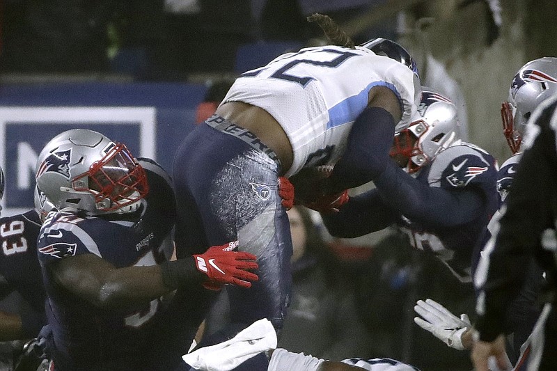 Tennessee Titans running back Derrick Henry goes over New England Patriots defenders for a touchdown in the first half of their NFL wild-card playoff game last Saturday night in Foxborough, Mass.