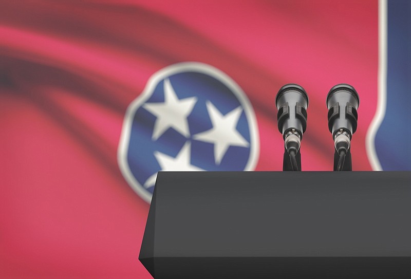 Podium with microphones with Tennessee state flag in background campaign finance tile. / Getty Images/iStockphoto/Niyazz