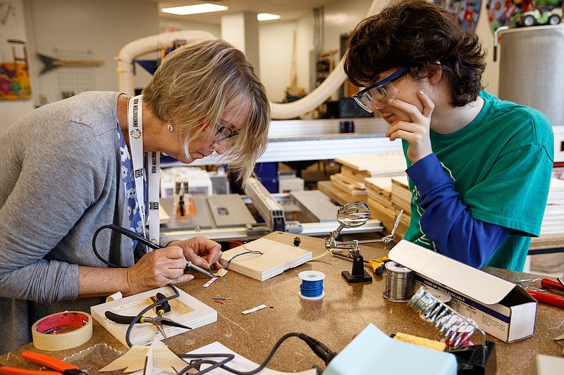 Red Bank student Lake Stolpmann, right, helps Alice Sikkema as she solders part of her project on the final day of the Public Education Foundation's Chattanooga Fab Institute at Chattanooga School for the Arts and Sciences on Wednesday, June 19, 2019, in Chattanooga, Tenn. Teachers worked in Volkswagen eLabs across the school district to complete design projects during the event.