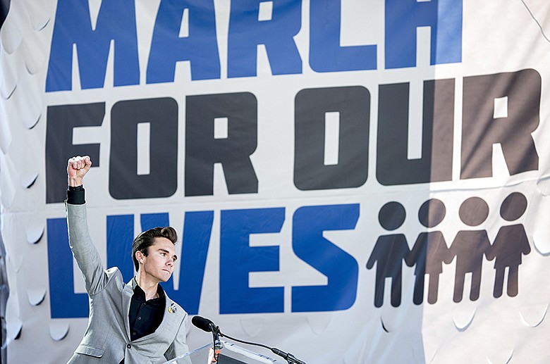 In this March 24, 2018, file photo, David Hogg, a survivor of the mass shooting at Marjory Stoneman Douglas High School in Parkland, Fla., raises his fist after speaking during the March for Our Lives rally in support of gun control in Washington. Students from Marjory Stoneman Douglas High School who began speaking out for gun reform faced accusations that some were "crisis actors" and the group was under the manipulation of gun control advocates. (AP Photo/Andrew Harnik, File)