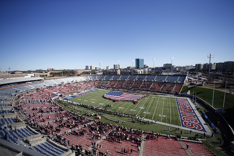 This Dec. 30, 2019, file photo shows many empty seats as a flag is displayed on the field before the NCAA First Responder Bowl college football game between Western Michigan and Western Kentucky in Dallas. Bowls outside the College Football Playoff structure might excite only the most ardent fans of the participating teams, be played in half-empty stadiums and prompt howls about there being too many games. They aren't going away, though. There'll be three more next season, bringing the total number of bowls to 42. (AP Photo/Roger Steinman, File)