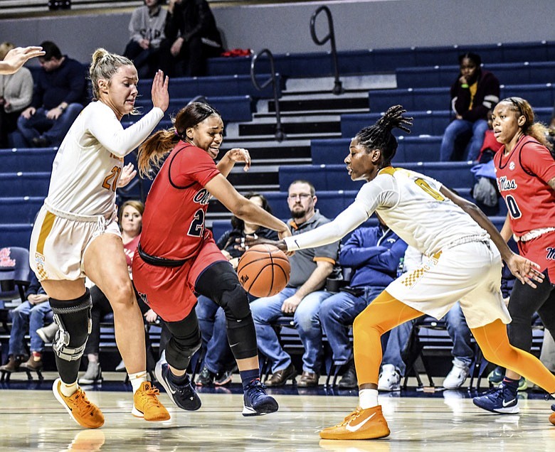 Mississippi guard Taylor Smith (21), center, loses the ball off her knee and out of bounds for a turnover while defended by Tennessee forward Lou Brown (21), left, and guard Rennia Davis (0) during an NCAA college basketball game in Oxford, Miss., Thursday, Jan. 9, 2020. (Bruce Newman/The Oxford Eagle via AP)