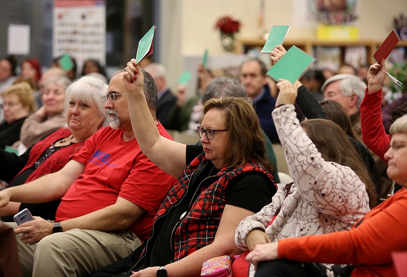 Staff photo by Erin O. Smith / Lori Cleveland, a special education teacher at Orchard Knob Elementary, and Heather Modrow, a special education teacher at East Ridge Elementary, hold up green cards to indicate they agree with the speaker during a Hamilton County school board and Hamilton County Commission joint meeting Monday, December 9, 2019 at Red Bank Middle School in Red Bank, Tennessee. The cards, which had green on one side and red on the other, gave community members and teachers the ability to give some input while allowing the board and commissioners to continue their conversations.