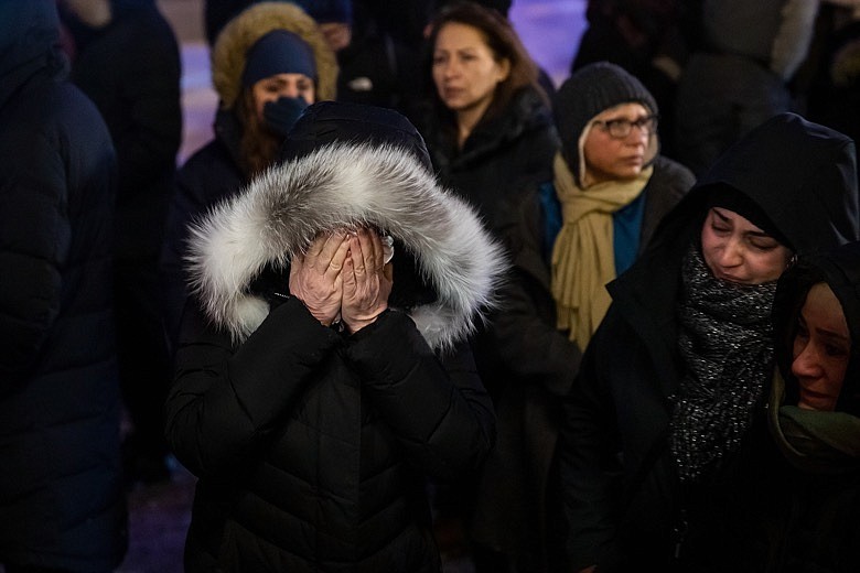 A woman mourns outside the Alberta Legislature Building in Edmonton, Alberta, Wednesday, Jan. 8, 2020, during a vigil for those killed after a Ukrainian passenger jet crashed, killing at least 63 Canadians, just minutes after taking off from Iran's capital. (Codie McLachlan/The Canadian Press via AP)