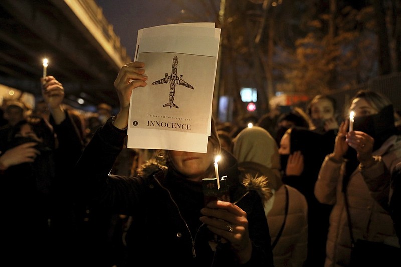 People gather for a candlelight vigil to remember the victims of the Ukraine plane crash, at the gate of Amri Kabir University that some of the victims of the crash were former students of, in Tehran, Iran, Saturday, Jan. 11, 2020. Iran on Saturday, Jan. 11, acknowledged that its armed forces "unintentionally" shot down the Ukrainian jetliner that crashed earlier this week, killing all 176 aboard, after the government had repeatedly denied Western accusations that it was responsible. (AP Photo/Ebrahim Noroozi)