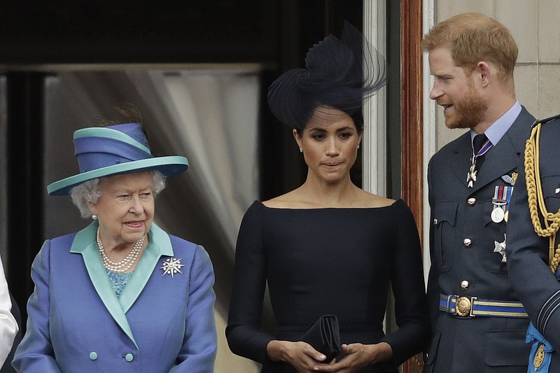File photo by Matt Dunham of The Associated Press / Britain's Queen Elizabeth II, Meghan the Duchess of Sussex and Prince Harry stand on a balcony to watch a flypast of Royal Air Force aircraft pass over Buckingham Palace in London in Julyf 2018.