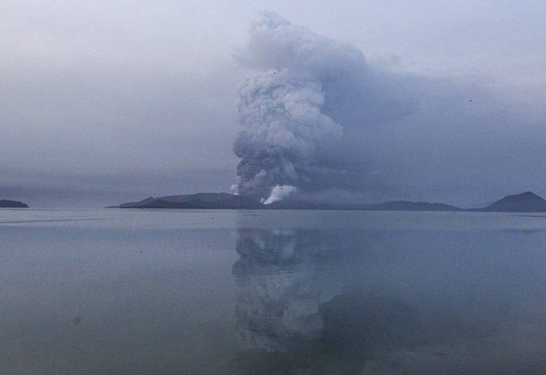 Taal volcano spews ash in view from Batangas, southern Philippines on Monday, Jan. 13, 2020. Red-hot lava gushed out of a volcano near the Philippine capital on Monday, as thousands of people fled the area through heavy ash. Experts warned that the eruption could get worse and plans were being made to evacuate hundreds of thousands. (AP Photo/Gerrard Carreon)