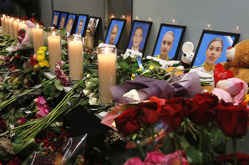 Flowers and candles are placed in front of portraits of the flight crew members of the Ukrainian 737-800 plane that crashed on the outskirts of Tehran, at a memorial inside Borispil international airport outside Kyiv, Ukraine, Saturday, Jan. 11, 2020. Ukraine's President Volodymyr Zelenskiy says that Iran must take further steps following its admission that one of its missiles shot down Ukrainian civilian airliner. He also expressed hope for the continuation of the crash investigation without delay. A team of Ukrainian investigators is in Iran. (AP Photo/Efrem Lukatsky)