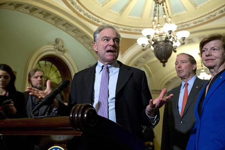 Sen. Tim Kaine D-Va., accompanied by Sen. Tammy Baldwin, D-Wis., and other senators, speaks during a news conference outside of the Senate chamber, on Capitol Hill in Washington, Tuesday, Jan. 14, 2020. (AP Photo/Jose Luis Magana)