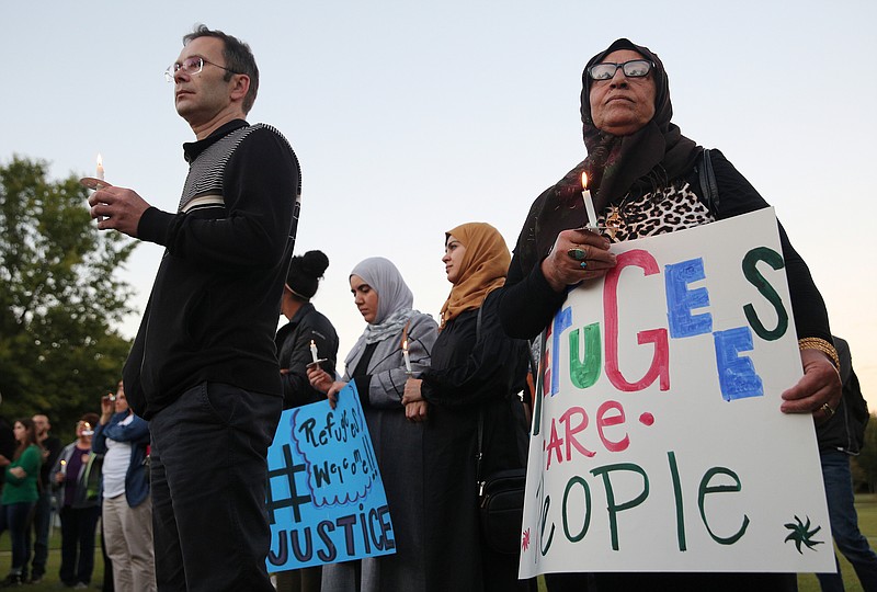 Jasmin Foric from Bosnia and Najar Alsad from Iraq hold candles Wednesday, Oct. 18, 2017, during a We All Belong vigil at Coolidge Park in Chattanooga, Tenn. / Staff file photo by Erin O. Smith