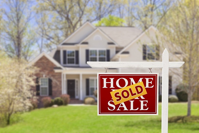 Sold Home For Sale Real Estate Sign and House. / Getty Images/iStockphoto/Feverpitched