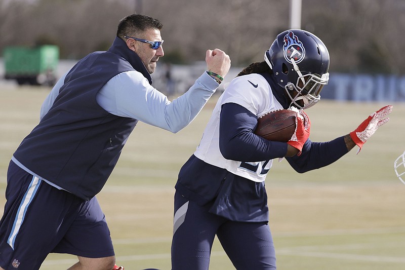 AP photo by Mark Humphrey / Tennessee Titans coach Mike Vrabel tries to knock the ball away from running back Derrick Henry, a former Alabama Crimson Tide star, during practice ahead of the AFC championship game this past January.