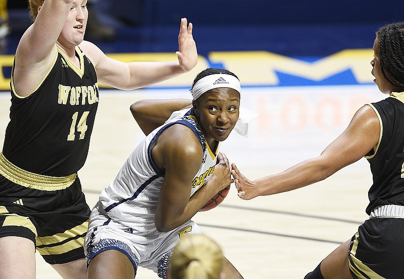 UTC's Eboni Williams, center, keeps her eyes on the basket as she forces her way between Wofford's Lilly Hatton, left, and Laren Cook during a SoCon game Jan. 16 at McKenzie Arena. Williams had 25 points and 16 rebounds to help the Mocs win in triple overtime Saturday at East Tennessee State. / Staff photo by Robin Rudd