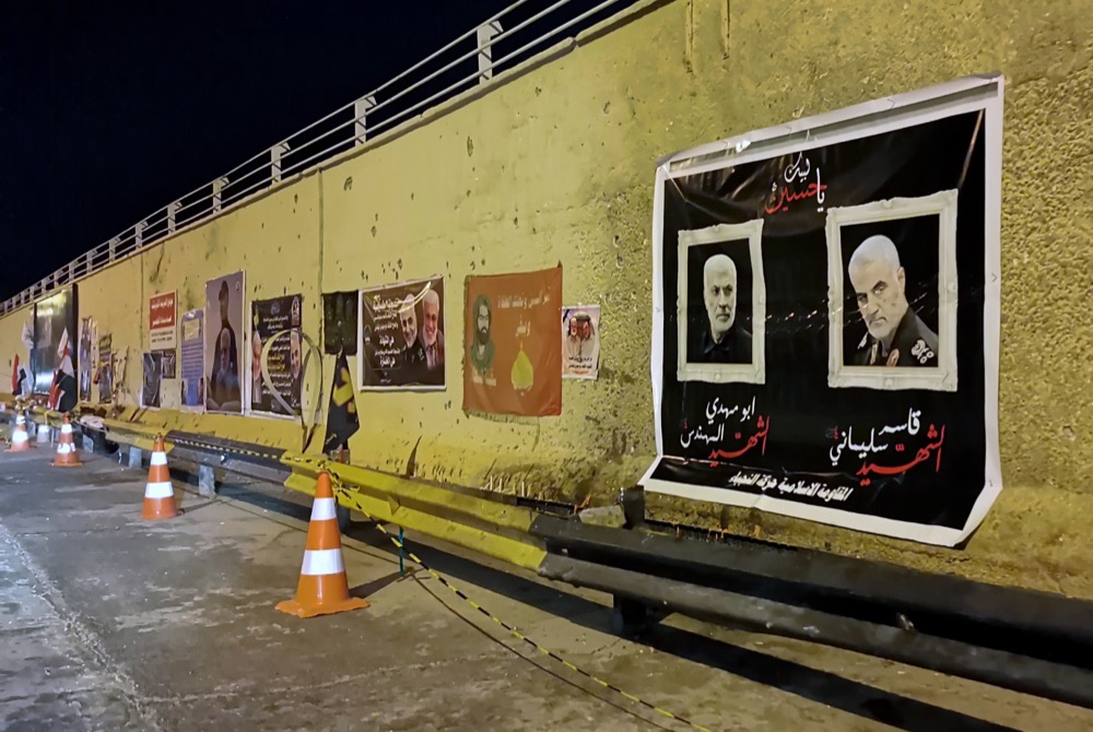 Posters of the killed Iranian General Qassem Soleimani and, deputy commander of Iran-backed militias Abu Mahdi al-Muhandis, along with their companions adorn bullet-ridden blast walls at the site of the U.S. strike that killed them. Images of revered Shiite religious figures were also put up in tribute, in Baghdad, Iraq, Thursday, Jan. 16, 2020. (AP Photo/Hadi Mizban)