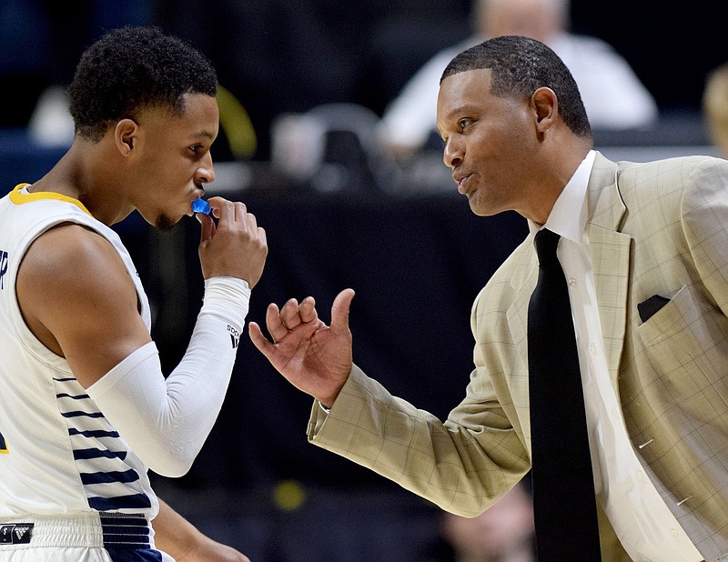 Staff photo by Robin Rudd / UTC men's basketball coach Lamont Paris confers with sophomore guard Maurice Commander during a SoCon game against Furman on Jan. 8 at McKenzie Arena. In Saturday's 84-77 win at Wofford, Commander scored 22 points, his most as a Moc.