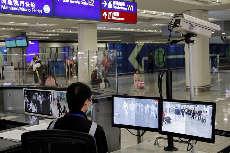 FILE - In this Jan. 4, 2020, file photo, a health surveillance officer monitors passengers arriving at the Hong Kong International airport in Hong Kong. (AP Photo/Andy Wong, File)


