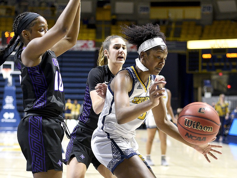UTC's Eboni Williams loses control of the ball under the defensive pressure of Furman's Le'Jzae Davison, left, and Taylor Petty during Saturday's game at McKenzie Arena. Williams, though, led her team in assists, rebounds and steals to help the Mocs win 60-52. / Staff photo by Robin Rudd