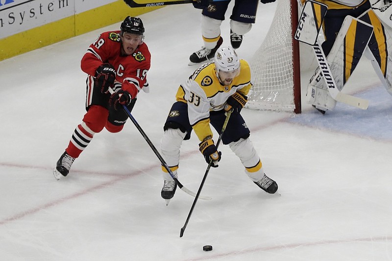 Nashville Predators right wing Viktor Arvidsson, right, controls the puck against Chicago Blackhawks center Jonathan Toews during the first period of their teams' game on Jan. 9 in Chicago. / AP photo by Nam Y. Huh


