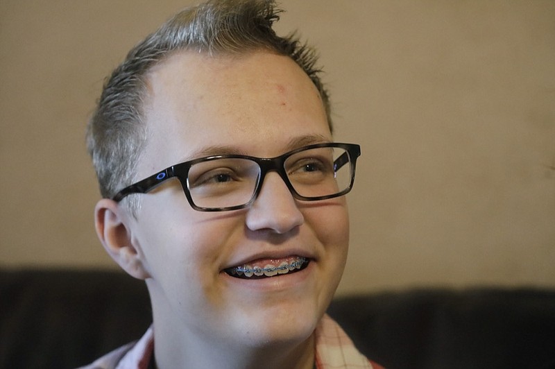 Dex Rumsey, 15, smiles as he talks with his father Friday, Jan. 17, 2020, in Roy, Utah. Dex Rumsey, 15, of Roy, Utah, came out as transgender at age 12. In consultation with a counselor and doctors, he gradually began wearing short hair and boy's clothes, then began using puberty blockers and eventually testosterone. His parents say he's gone from a shy, withdrawn child to a happy, thriving kid. He scared he could become depressed and suicidal again a ban on hormone therapy and sex-reassignment surgery for minors were to pass. (AP Photo/Rick Bowmer)


