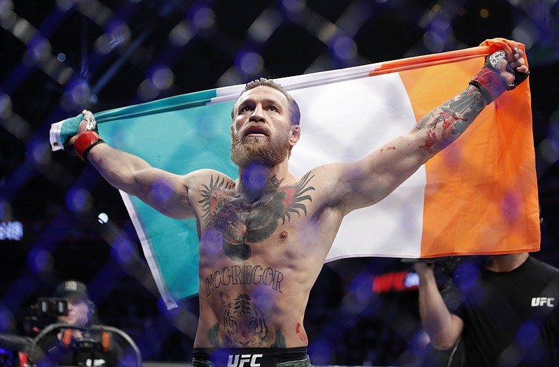 Conor McGregor holds Ireland's flag in celebration after defeating Donald "Cowboy" Cerrone during a welterweight bout Saturday night at UFC 246 in Las Vegas. / AP photo by John Locher