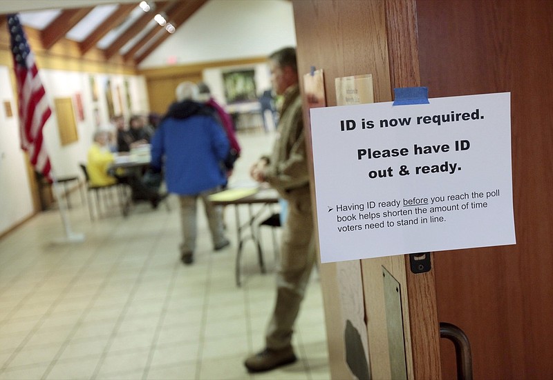 FILE - In this Feb. 16, 2016, file photo, a sign informs voters of the need for identification at the Olbrich Gardens polling location in Madison, Wis. Democrats are hoping this is the year they can finally make political headway in Texas and have set their sights on trying to win a majority in one house of the state legislature. Among the big hurdles they'll have to overcome are a series of voting restrictions Texas Republicans have implemented in recent years, including the nation's toughest voter ID law, purging of voter rolls and reductions in polling places. (Michael P. King/Wisconsin State Journal via AP, File)