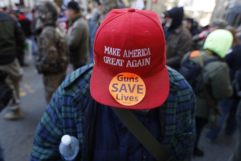 A man walks in the crowd during a pro-gun rally, Monday, Jan. 20, 2020, in Richmond, Va. Thousands of pro-gun supporters are expected at the rally to oppose gun control legislation like universal background checks that are being pushed by the newly elected Democratic legislature. (AP Photo/Julio Cortez)