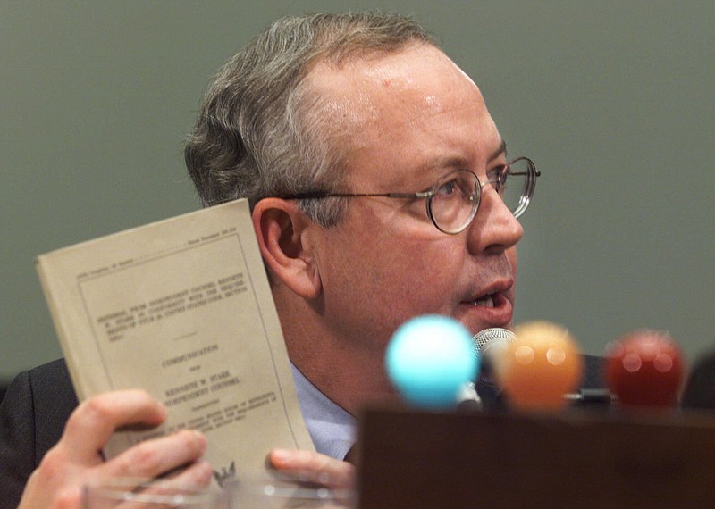 File photo by Joe Marquette of The Associated Press / In this Nov. 19, 1998 photo, Independent Counsel Kenneth Starr holds up his report while testifying on Capitol Hill in Washington before the House Judiciary Committee's impeachment hearing.