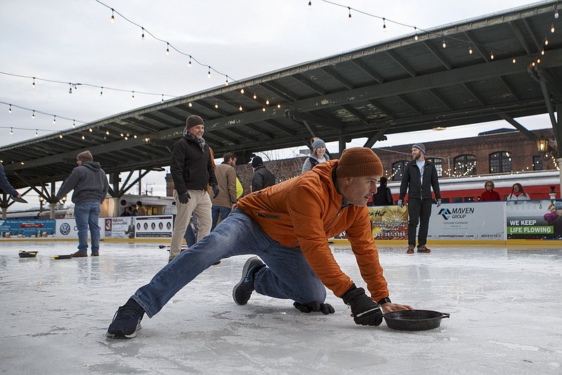 Slippery When Frozen team member Alvaro Victoria prepares to throw a skillet during the Iron Skillet Curling tournament at Ice on the Landing in the Chattanooga Choo Choo Gardens on Tuesday, Jan. 22, 2019 in Chattanooga, Tenn. The tournament, played more like bocce ball than curling, was contested by sixteen teams. The 4-person teams competed in the single-elimination tournament with the winning team taking home a custom trophy made by Lodge Cast Iron and each member getting a Lodge Cast Iron pan and pound of bacon from Main Street Meats. Staff Photo by C.B. Schmelter. 
