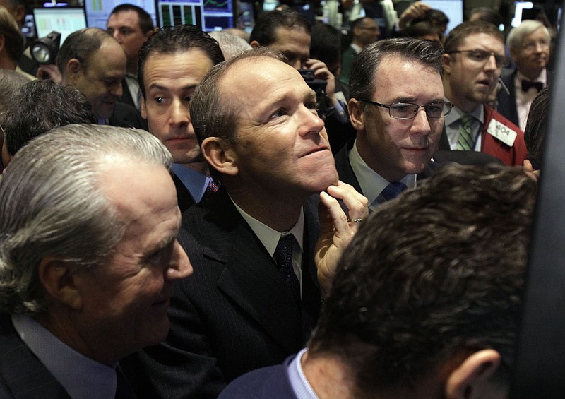 FILE - In this Jan. 26, 2011 file photo, Nielsen Company CEO David Calhoun, center, watches progress as he waits for the company's IPO to begin trading, on the floor of the New York Stock Exchange. Calhoun, Boeing's new CEO, said Wednesday, Jan. 22, 2020, that production of the 737 Max will resume this spring, months before the company expects federal regulators to certify the grounded plane to fly again. (AP Photo/Richard Drew, File)