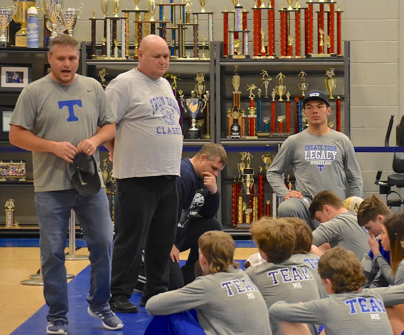 Trion coach Eric Brock, left, and assistant Jarin Blevins, middle, talk to their wrestling team Monday at the school. The Bulldogs improved to 27-0 in duals this season with their 46-25 victory against Commerce to win the GHSA Class A title this past Saturday in Macon. / Staff photo by Patrick MacCoon