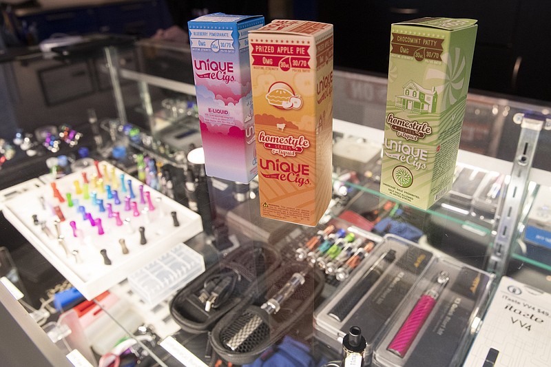 Photo by Mary Altaffer of The Associated Press / This Jan. 2, 2020, file photo shows flavored vaping liquids and devices on display at the VapeNY.com store in New York.