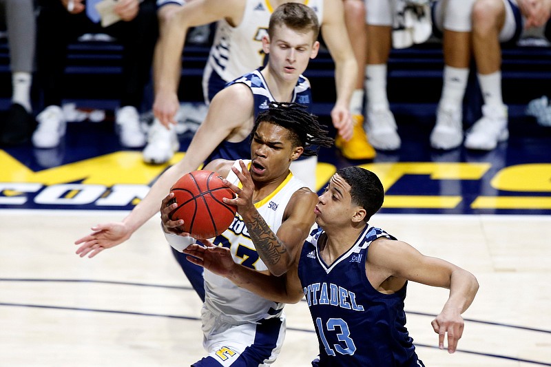 Staff photo by C.B. Schmelter / The Citadel guard Tyson Batiste (13) fouls UTC counterpart Trey Doomes as he drives to the basket on Jan. 22 at McKenzie Arena.