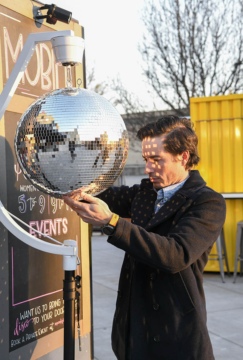 Andrew Coleman sets up the disco ball./ Photography by Mark Gilliland