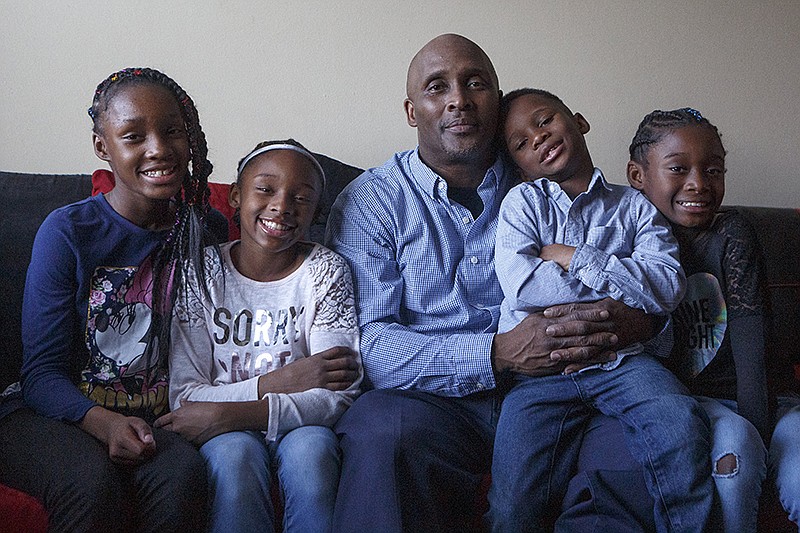 Marvin Roseberry, center, poses with his children, 12-year-old Marnaysha, from left, 10-year-old Maliyah, 6-year-old Christian and 9-year-old Mariyah at their home in Chattanooga. / Staff photo by C.B. Schmelter