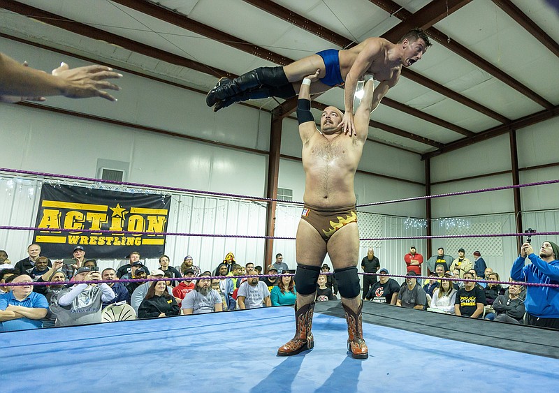 Former University of Iowa football player Steve Manders presses Tony Deppen over his head at an Action Wrestling event in Tyrone, Ga. Manders is among the wrestlers from across the nation who will wrestle in the Scenic City Rumble. / Contributed photo by Alec Thomas of Top Rope Images