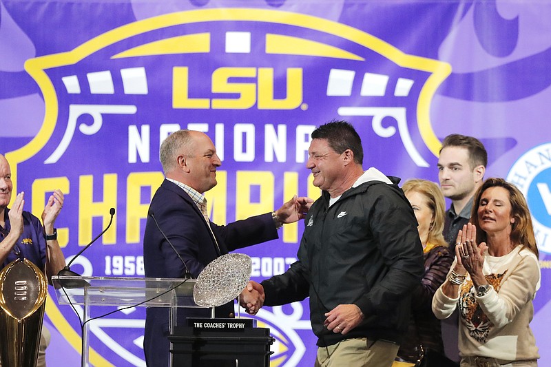 AP photo by Gerald Herbert / LSU football coach Ed Orgeron, right, is greeted by Louisiana Gov. John Bel Edwards during an on-campus celebration of the Tigers' 15-0 national championship season this past January in Baton Rouge, La.