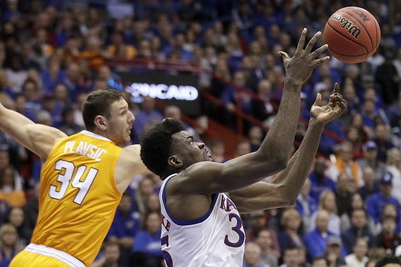 Kansas center Udoka Azubuike, right, wins a rebound battle with Tennessee forward Uros Plavsic during the first half of their teams' Big 12/SEC Challenge game Saturday in Lawrence, Kan. Azubuike had 18 points, 11 rebounds and four blocks to help the third-ranked Jayhawks win 74-68. / AP photo by Orlin Wagner